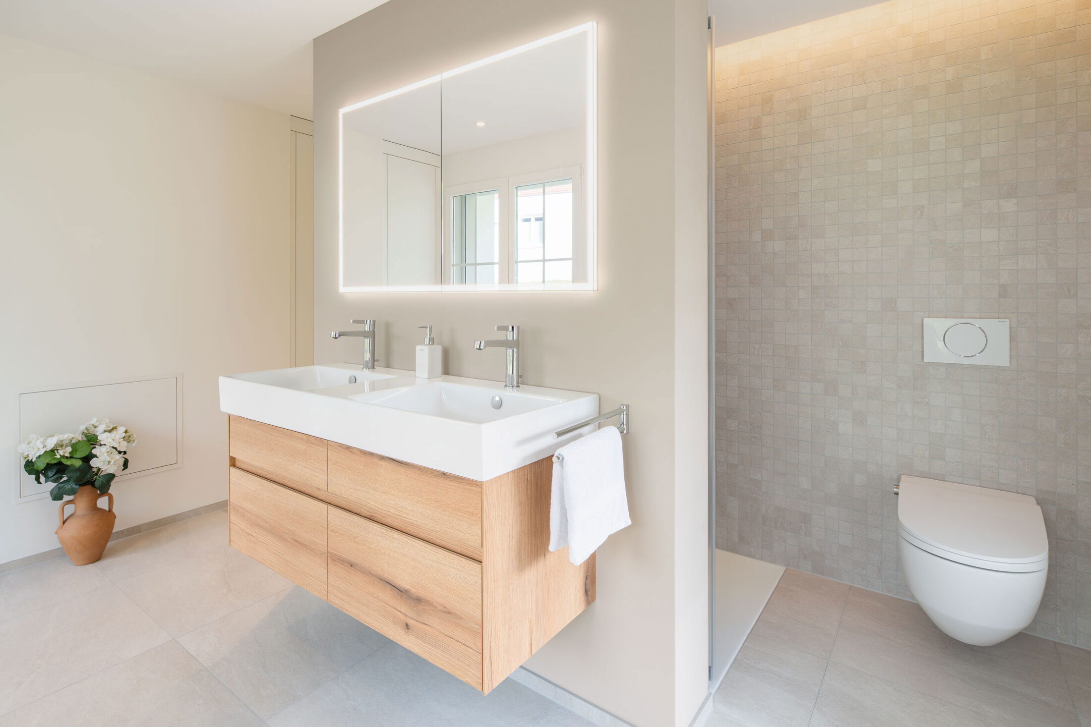 Badezimmer mit Waschtisch, Walk-in-Dusche und Toilette eines umgebauten Einfamilienhauses in Stans, Nidwalden